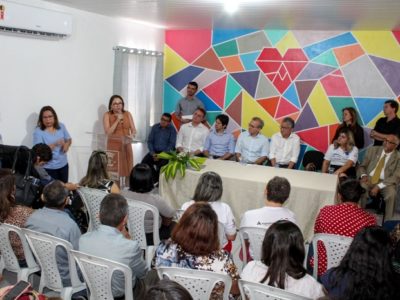 Mulher falando para público diante de plateia