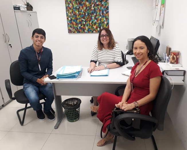 Pessoas sentadas em volta de uma mesa