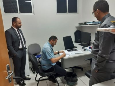 Pessoas sentadas assinando um documento