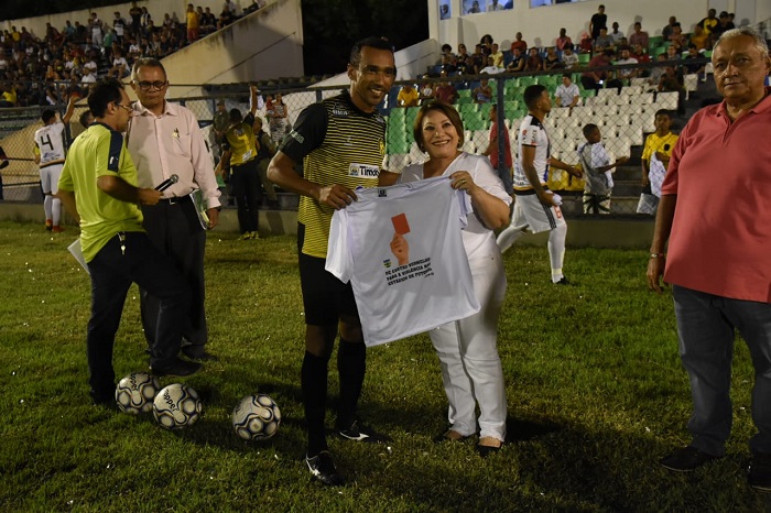 Pessoas de pé sorrindo e segurando uma camisa 
