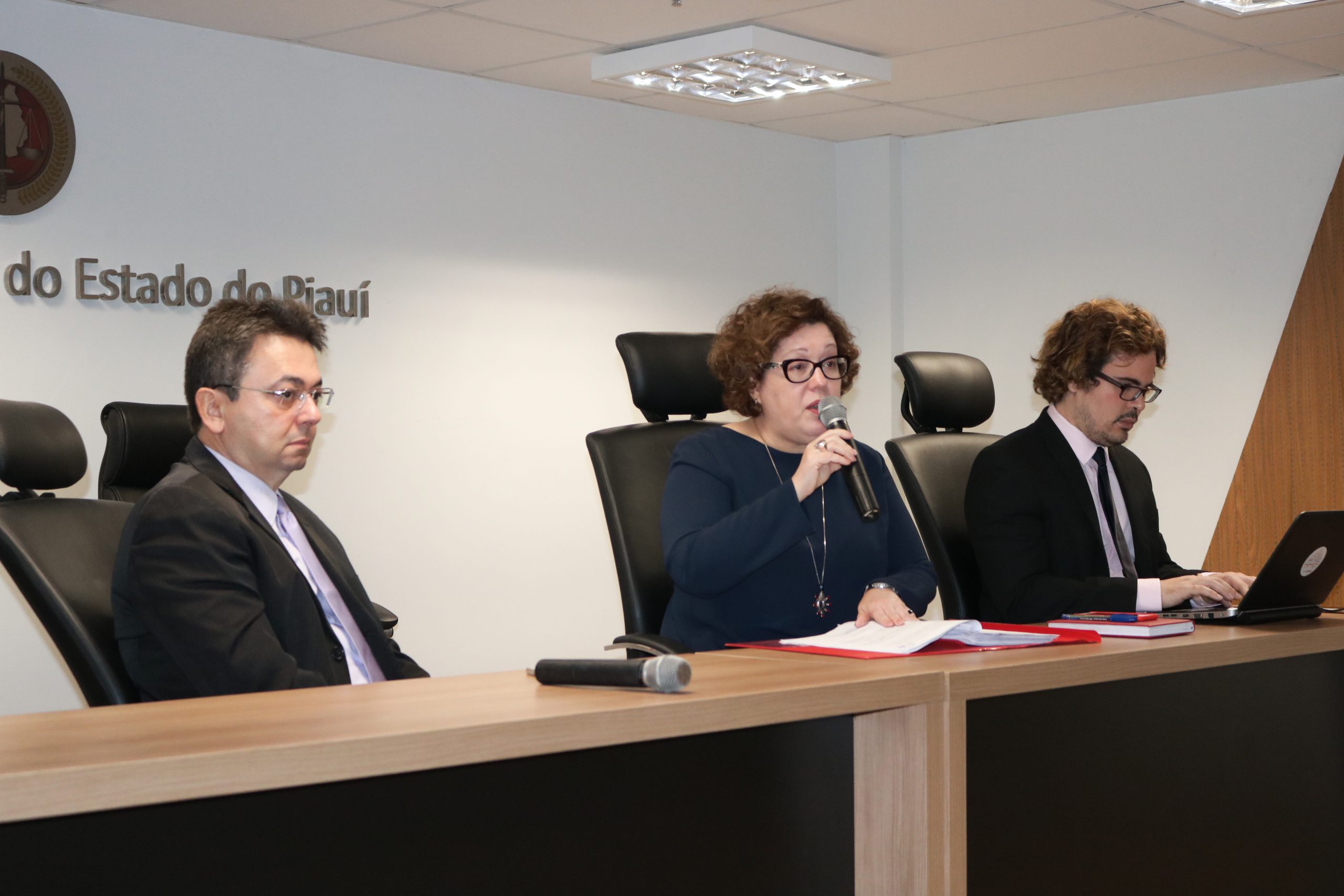 três pessoas sentadas numa bancada