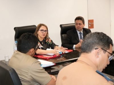 Pessoas sentadas atrás de uma mesa