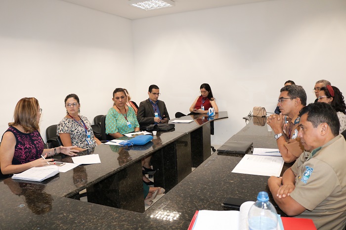 Pessoas sentadas atrás de uma mesa 