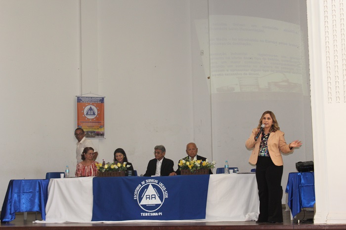 Mulher de pé falando pessoas que estão a sua frente