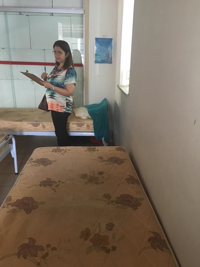 Pessoa de pé dentro de um quarto vistoriando as dependências do mesmo 