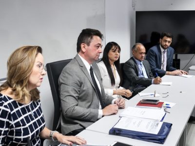 Pessoas sentadas atrás de uma mesa