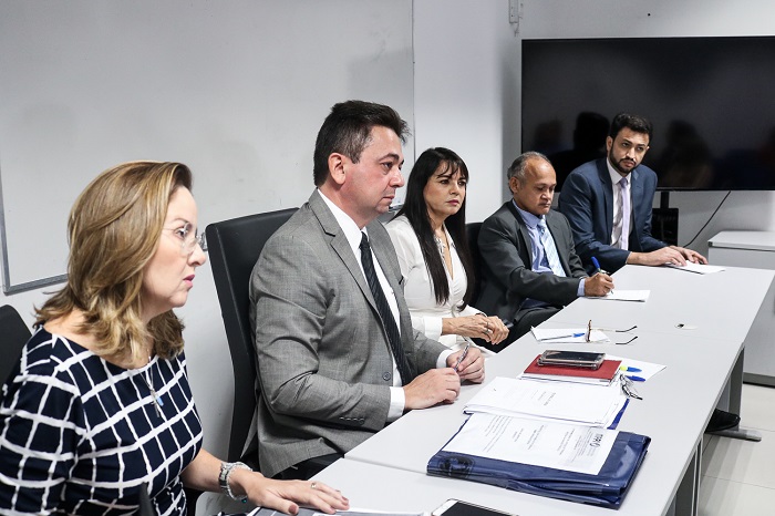 Pessoas sentadas atrás de uma mesa