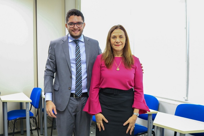 Duas pessoas de pé sorrindo 