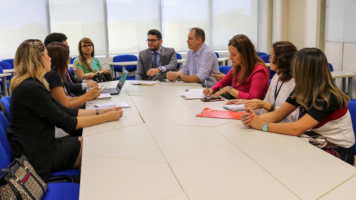 Pessoas sentadas em volta de uma mesa