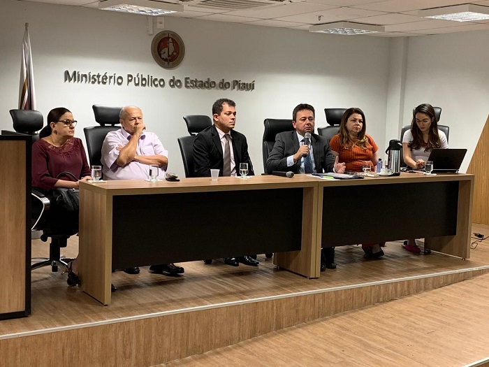Pessoas sentadas atrás de uma mesa