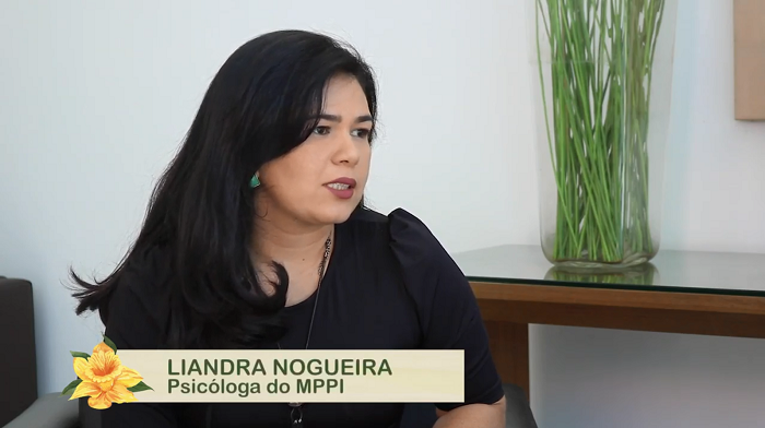 Mulher sentada em uma cadeira dando entrevista