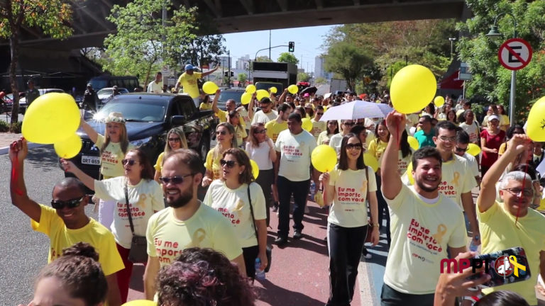 Pessoas caminhando em via pública com balões em mãos