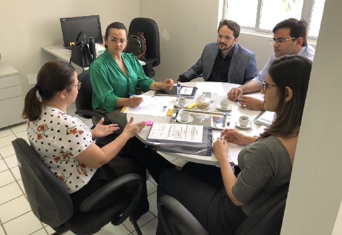 Pessoas sentadas em volta de uma mesa