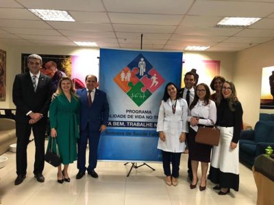Pessoas reunidas posando para foto em frente a um banner