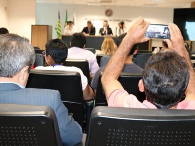 Pessoa com celular na mão registrando audiência pública