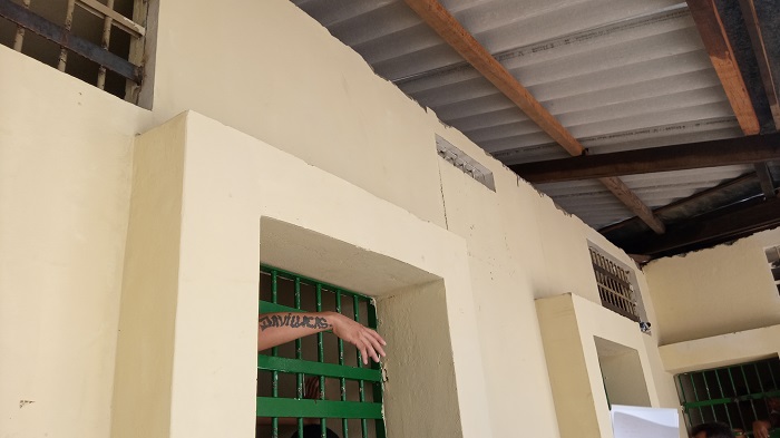 Foto de uma cela com uma mão do lado de fora 
