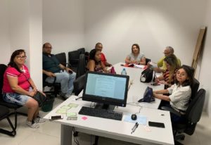 Pessoas sentadas em voltada de uma mesa