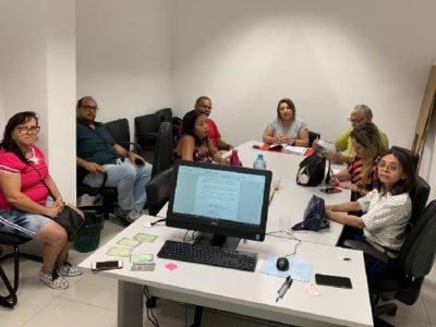 Pessoas sentadas em voltada de uma mesa