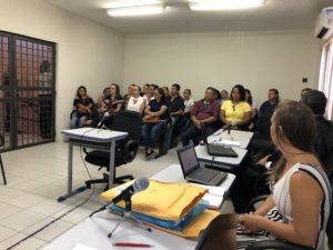 Pessoas sentadas em sala de audiência
