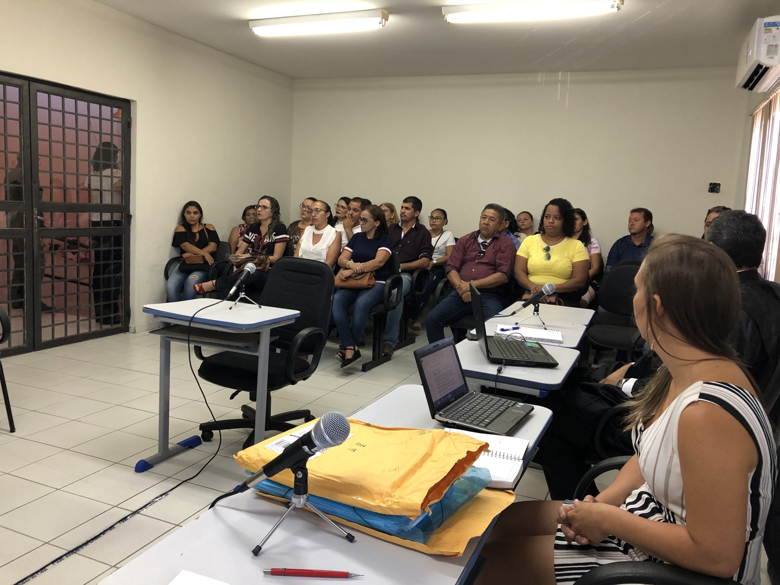 Pessoas sentadas em sala de audiência 