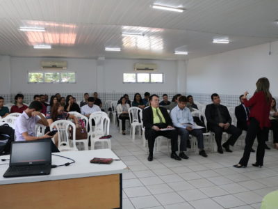 mulher de pé e pessoas sentadas