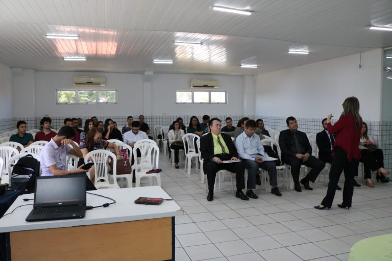 mulher de pé e pessoas sentadas