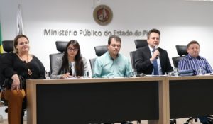 Pessoas sentadas atrás de uma mesa