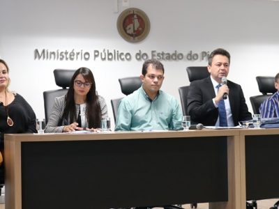 Pessoas sentadas atrás de uma mesa