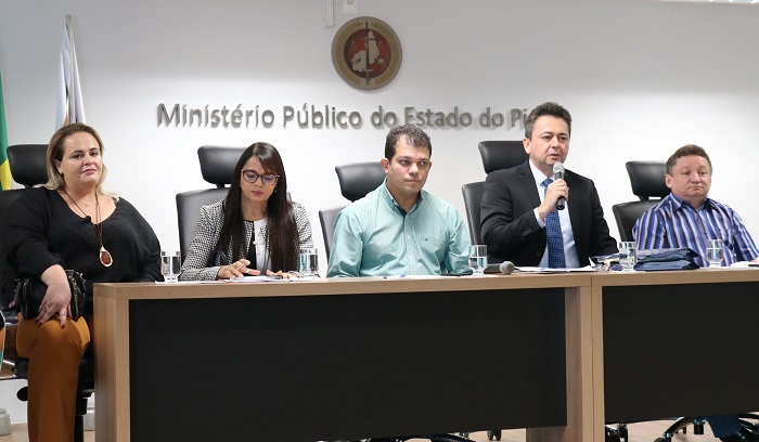 Pessoas sentadas atrás de uma mesa