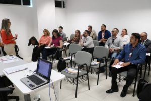 Pessoas reunidas numa sala durante oficina conduzida por melhor