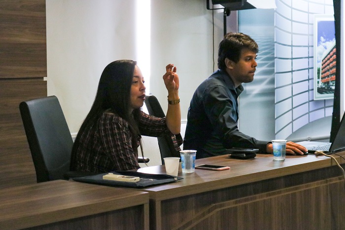 Mulher e homem sentados atrás da mesa