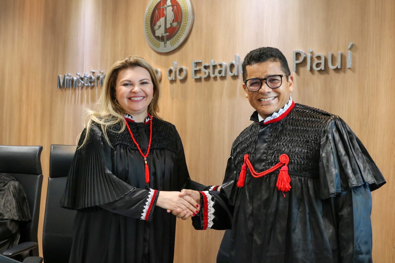 DUas pessoas de pé dando as mãos e sorrindo