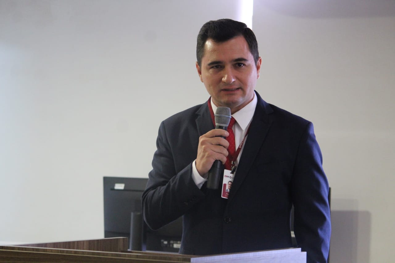 Pessoa de pé falando para o público 