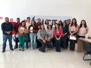 Pessoas de pé sorrindo. Atrás existe uma faixa com o nome e logomarca do CEAF/MPPI