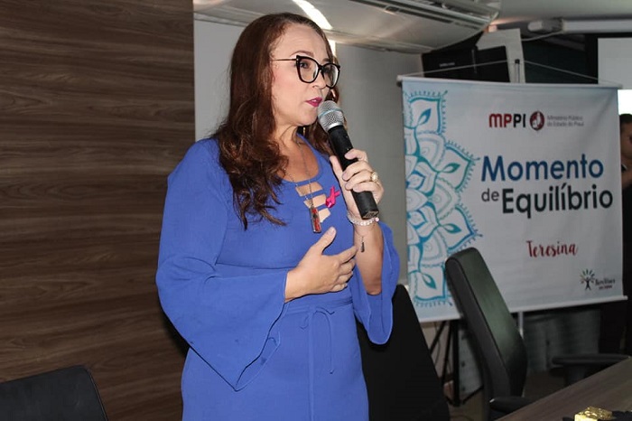 Mulher falando para público durante atividade de relaxamento