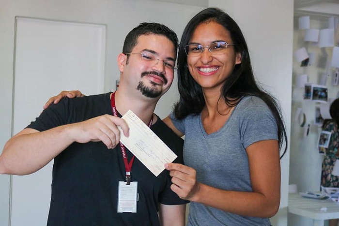Homem e mulher segurando cheque 