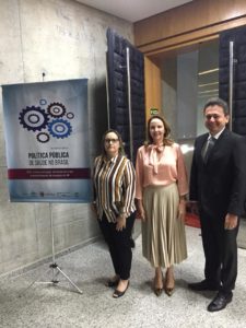 Promotores de Justiça do MPPI ao lado de banner de evento