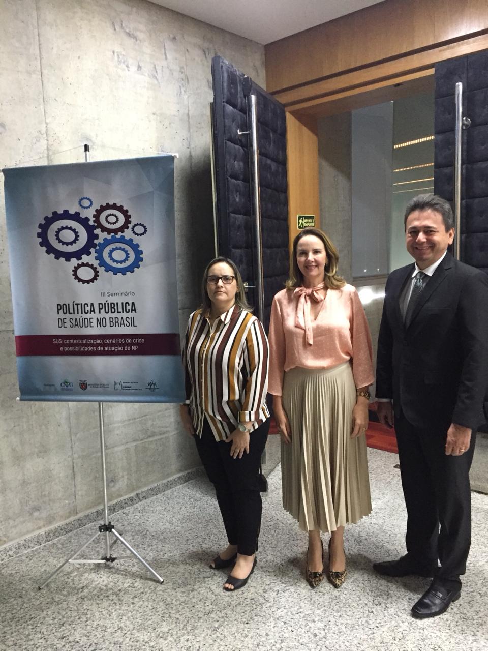 Promotores de Justiça do MPPI ao lado de banner de evento