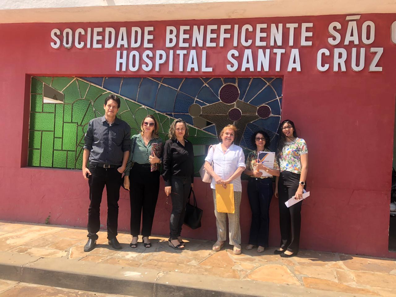 Pessoas em pé em frente à entrada do Hospital