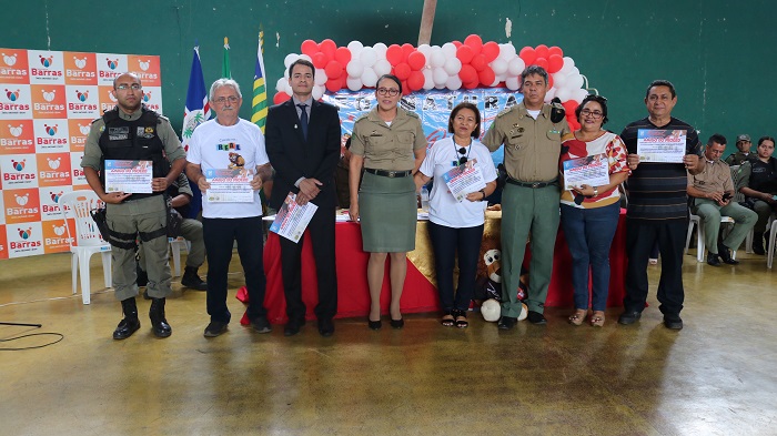 Pessoas de pé sorrindo e segurando um certificado 