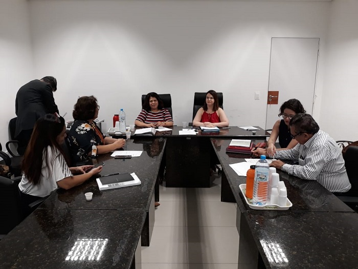 Pessoas sentadas em volta de uma mesa