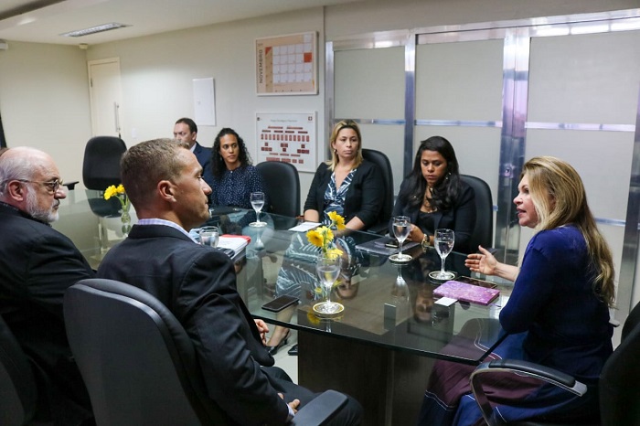 Pessoas sentadas em volta de uma mesa conversando entre si 