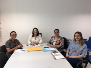 Pessoas sentadas envolta de uma mesa