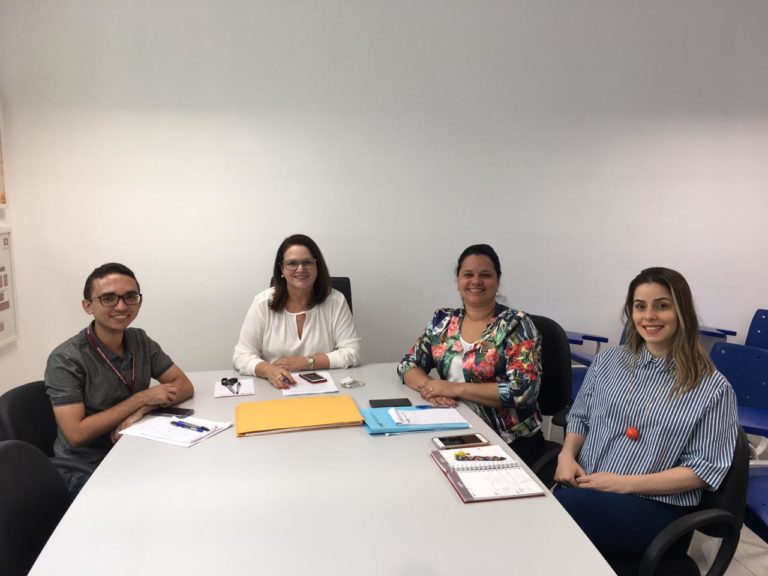Pessoas sentadas envolta de uma mesa