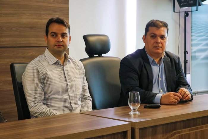 Duas pessoas entadas atrás de uma bancada 