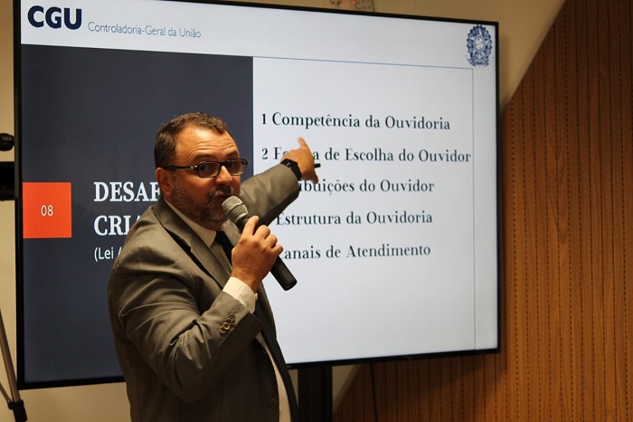 Homem falando diante de plateia 