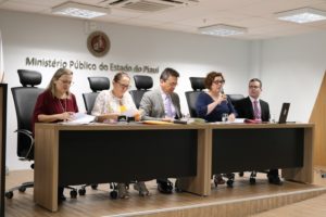 Pessoas sentadas atrás de uma bancada