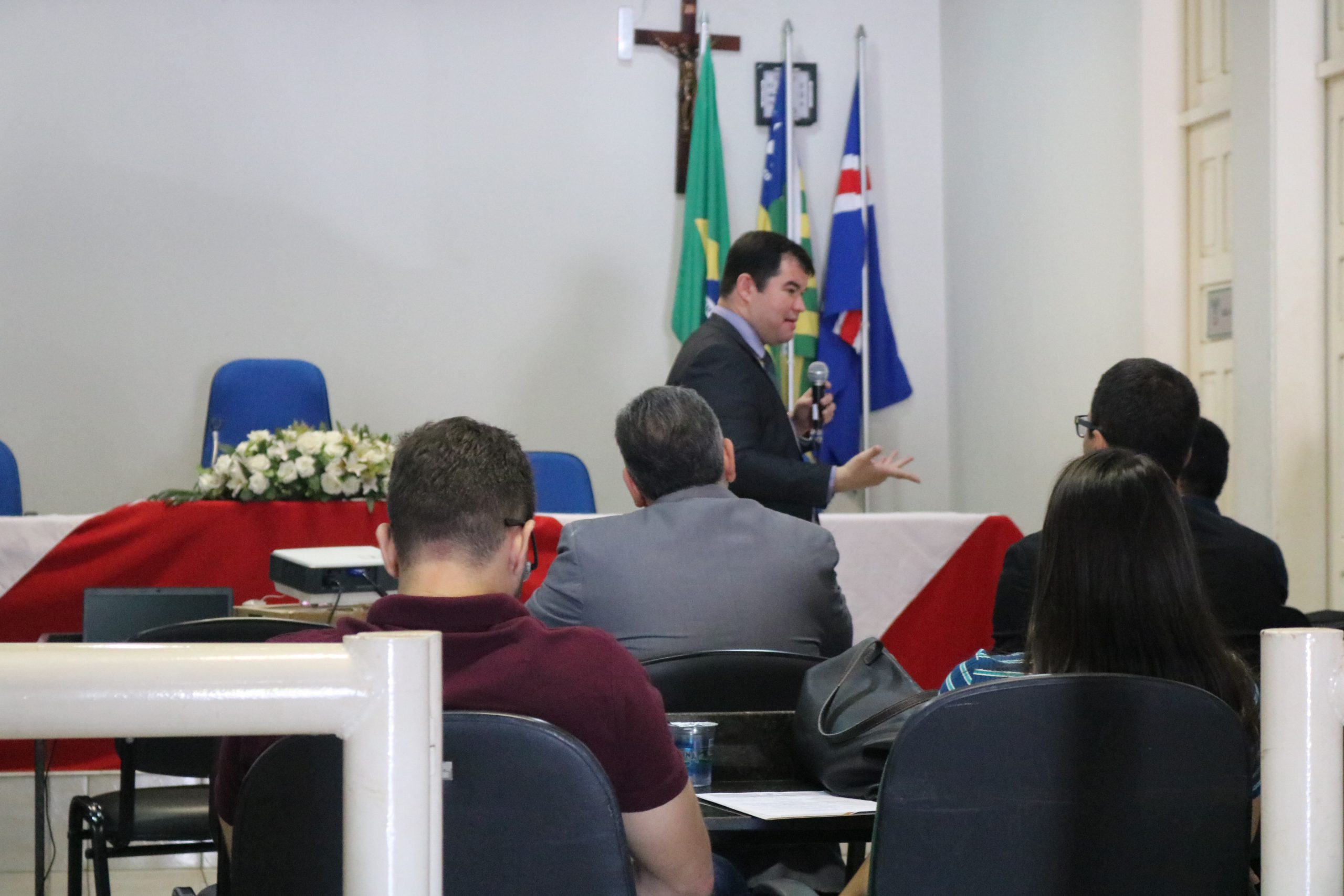 Homem falando diante de plateia 