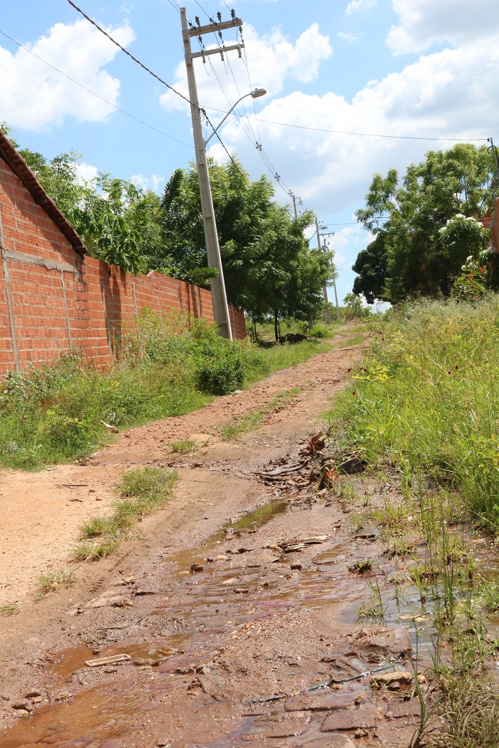 Ladeira sem calçamento e esgoto a céu aberto