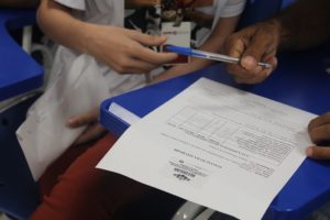 Pessoas segurando uma caneta e um papel